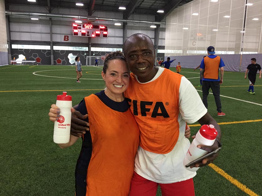Employés de CWB National Leasing souhaitant la bienvenue à de nouveaux arrivants dans le besoin avec un match de soccer amical