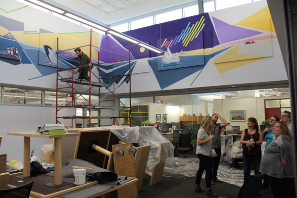 CWB National Leasing employees watch as Peter paints the mural