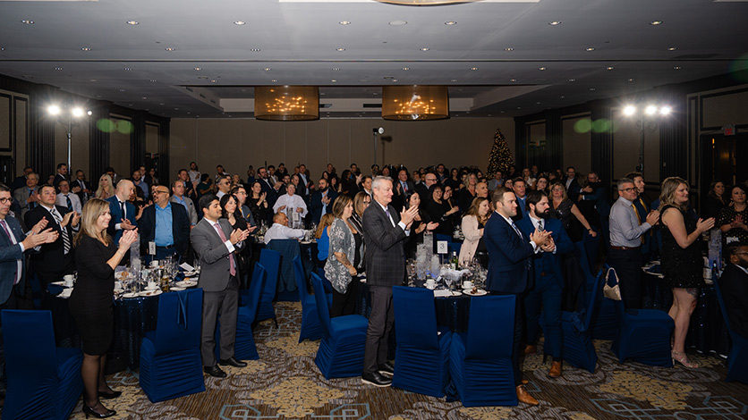 Les participants se lèvent et applaudissent nos gagnants à la cérémonie de remise des prix des ventes.