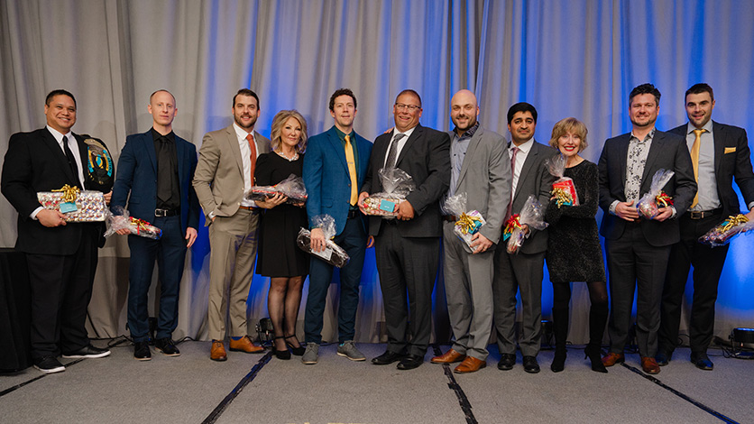 A few award winners throughout the night pose on stage at the Sales Awards.