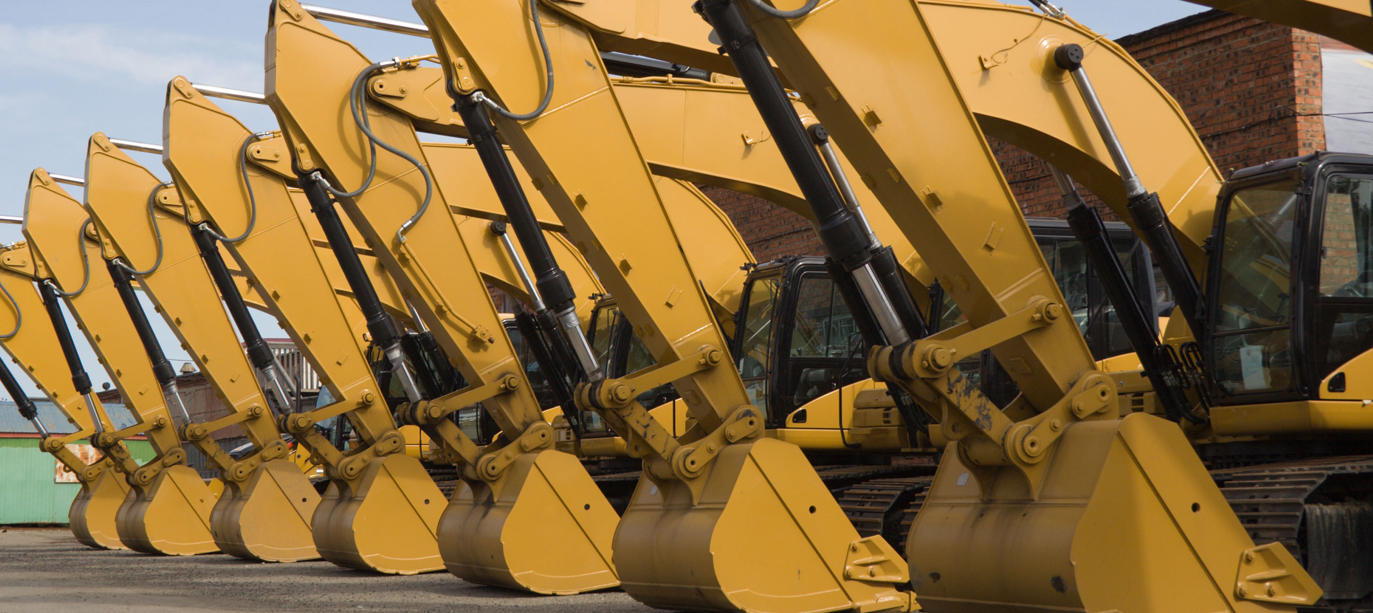 A row of parked backhoes