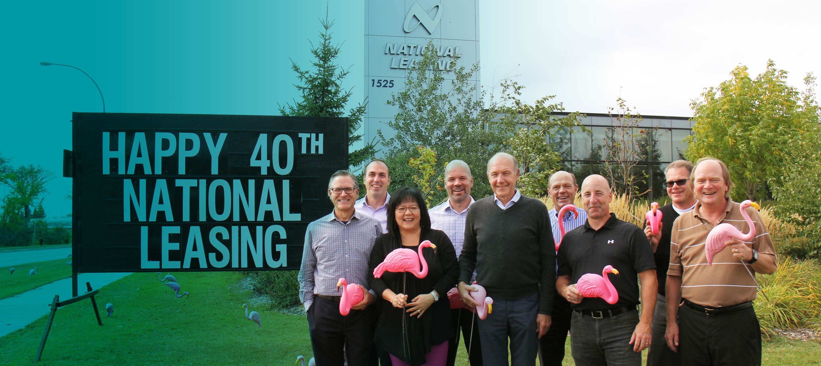 L'équipe de la haute direction de CWB National Leasing devant le panneau du 40e anniversaire