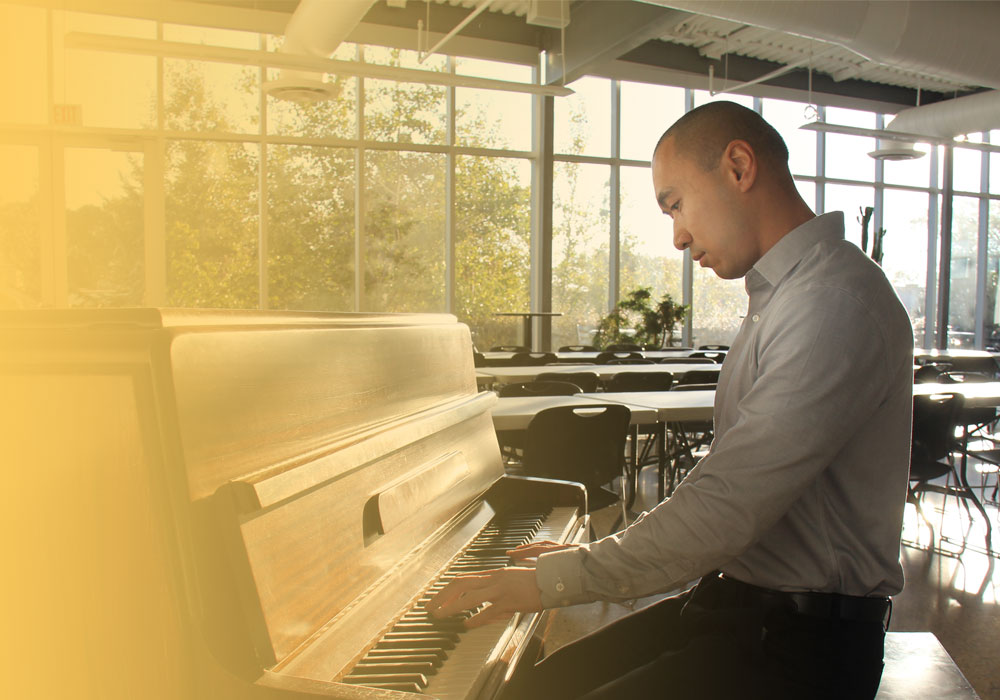 Employee playing piano in the lunch room