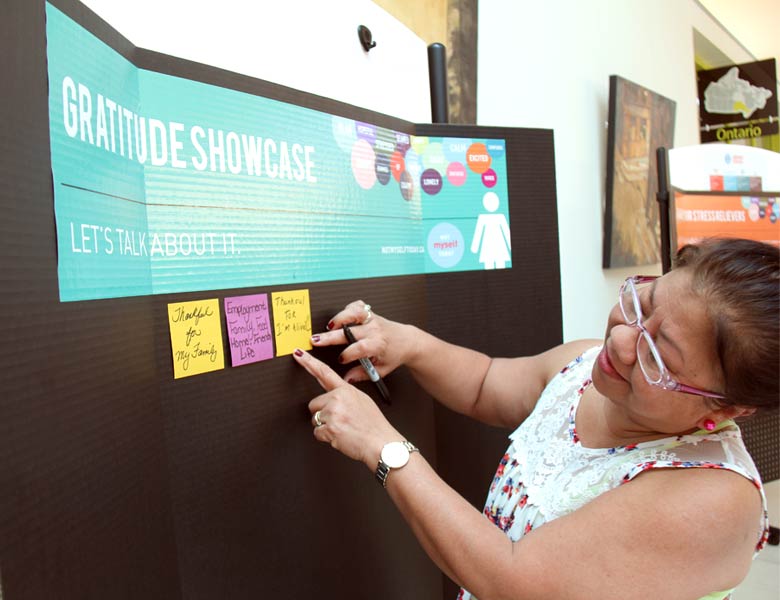 Employee adding a message to the Gratitude board on what she's thankful for